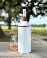 Wine & Champagne Chiller keeping bottle cool outdoors on a table.